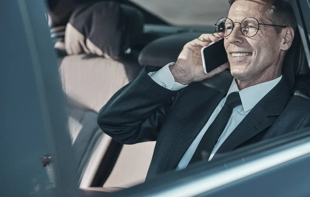 man smiling inside the car after airport pick up